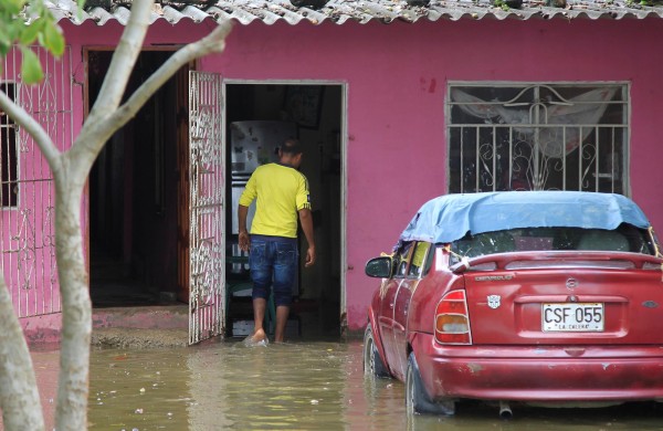 Un hombre entra a su casa inundada, en una fotografía de archivo.