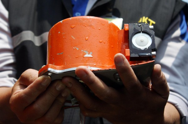 Un oficial indonesio muestra uno de los dos dispositivos de la caja negra del avión.