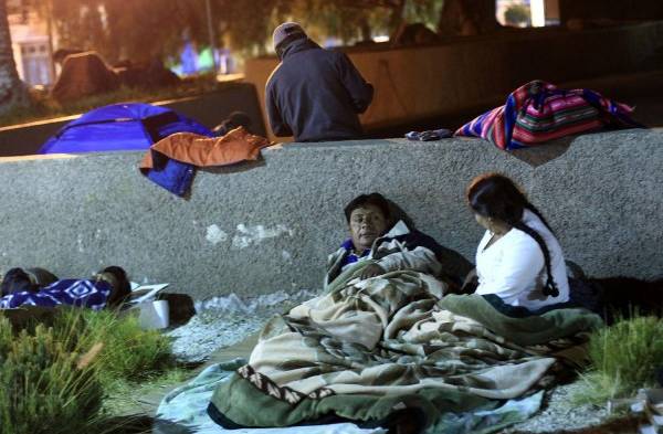 Niños y adultos duermen en las calles en la comunidad de Arica, luego de un segundo terremoto que sacudió ayer el mar frente a la costa norte de Chile en horas de la mañana.