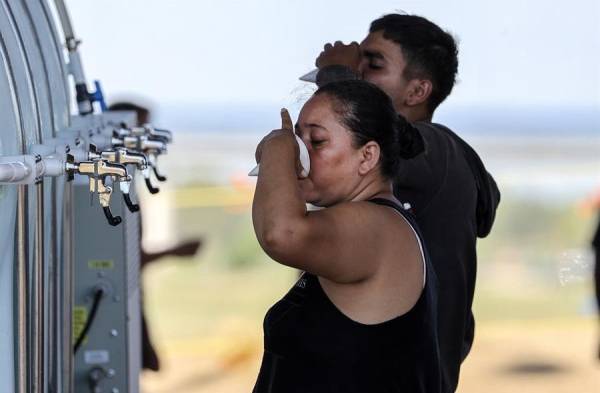 Los migrantes beben agua mientras esperan completar el papeleo en la frontera en Texas, en una fotografía de archivo.