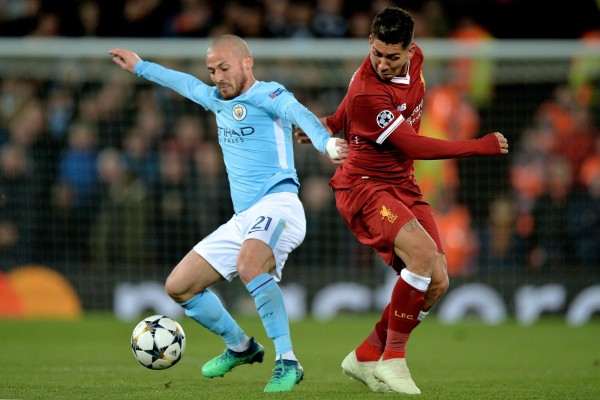 El jugador Roberto Firmino (d) de Liverpool disputa el balón con David Silva (i) de Manchester City.