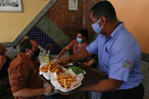 Un camarero atiende a clientes en un restaurante, en Río de Janeiro, en una fotografía de archivo.