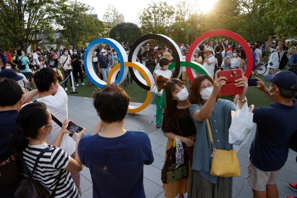 Varios curiosos se congregan delante del Estadio Olímpico, en Tokio.
