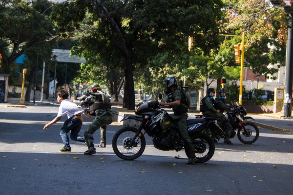 Miembros de la Guardia Nacional Bolivariana detienen a un manifestante durante una protesta de estudiantes, al este de Caracas, Venezuela.