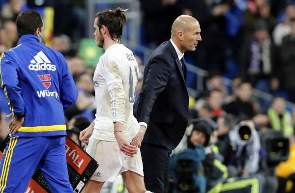 El delantero galés del Real Madrid, Gareth Bale (c), junto al técnico francés del el equipo blanco, Zinedine Zidane (d), tras ser sustituido durante el encuentro correspondiente a la decimonovena jornada de primera división.