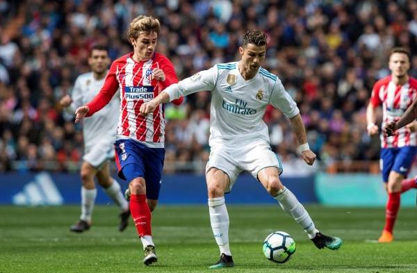 El delantero francés del Atlético de Madrid Antoine Griezmann (i) pelea un balón con el delantero portugués del Real Madrid.