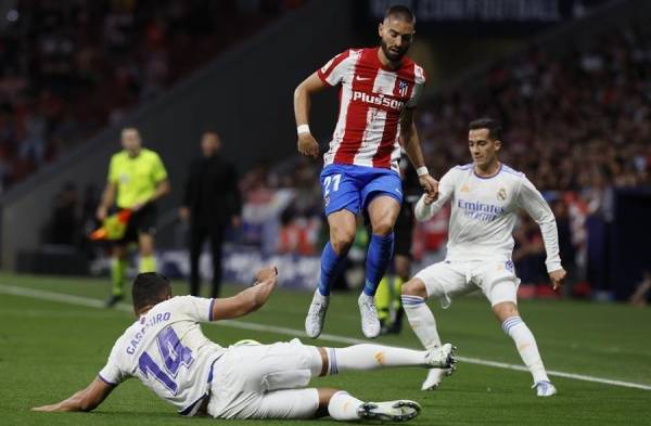 Casemiro (i), corta el balón ante el centrocampista belga del Atlético de Madrid, Yannick Carrasco.