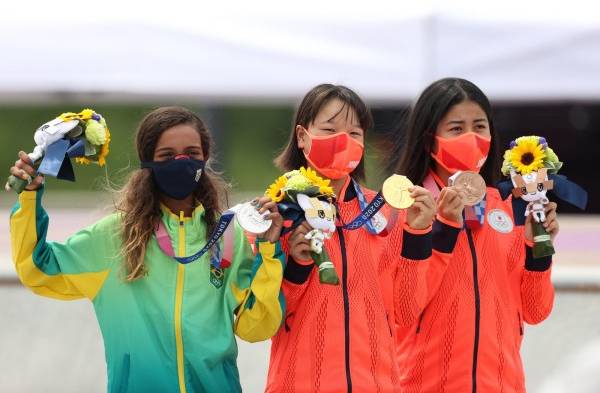 Momiji Nishiya (c-oro) de Japón, Rayssa Leal (i-plata) de Brasil, y Nakayama Funa (bronce) de Japón posan durante la ceremonia de entrega de medallas del street femenino de skateboarding en los Juegos Olímpicos 2020, este lunes en el Urban Sports Park de Ariake en Tokio (Japón).