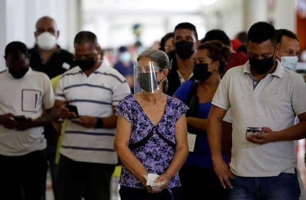 Varias personas hacen fila para ser vacunadas contra la covid-19, en un centro comercial