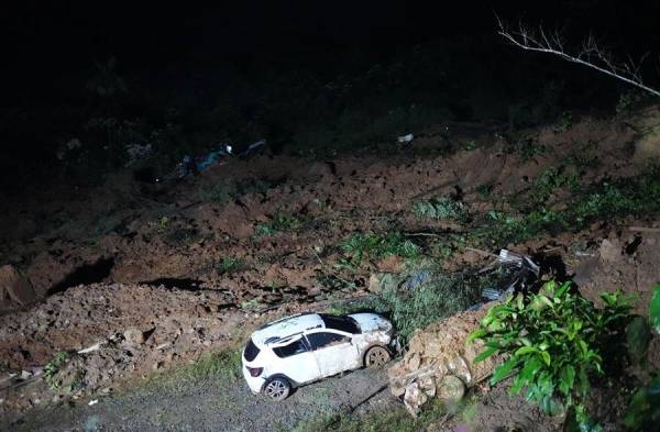 Restos de vehículos y lodo en el lugar donde ocurrió el derrumbe.