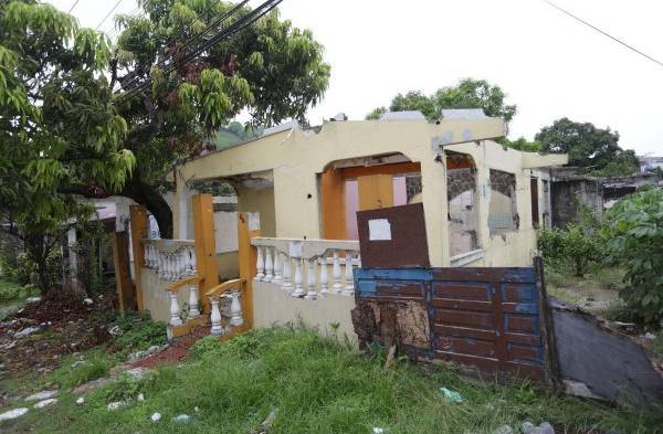 Dos casas que han sido abandonadas por propietarios están llenas de herbazales y desperdicios.