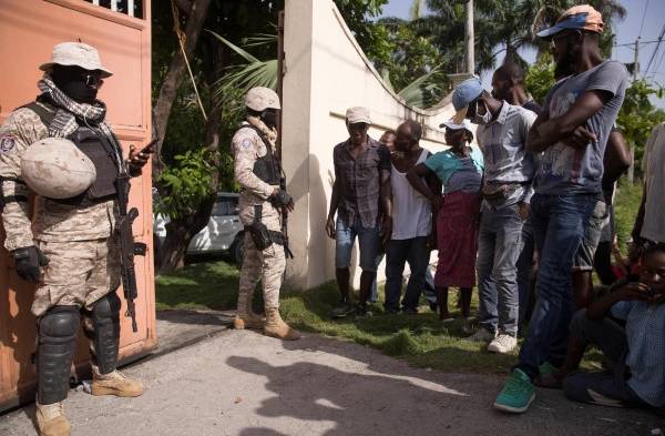 Personas esperan para recibir ayuda humanitaria entregada por una entidad privada hoy, en las afueras de Les Cayes (Haití).