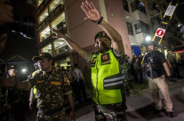 Policía del país intentando impedir el ingreso a un edifico atacado.