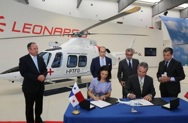 Firma del acuerdo y el helicóptero al fondo.