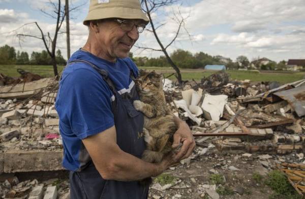 Anatoly un granjero de 60 años muestra a su gata Markisa, quien sobrevivió a los 5 misiles que impactaron en su casa.