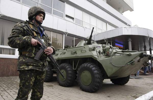 Soldado ucraniano hace guardia junto a un vehículo blindado en el exterior del aeropuerto Boryspil.