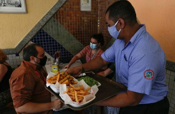 Un camarero atiende a clientes en un restaurante, en Río de Janeiro, en una fotografía de archivo.