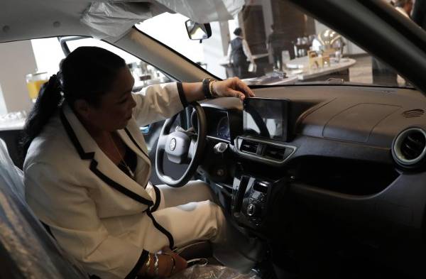 Una visitante fue registrada este lunes, 12 de diciembre, al observar el interior de un auto eléctrico presentado en la VII Semana de la Energía, en Ciudad de Panamá (Panamá).