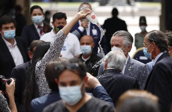 Una mujer lanza agua a Piñera durante un acto conmemorativo por la pandemia