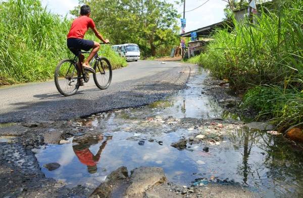 Calle está llena de cráteres y aguas servidas