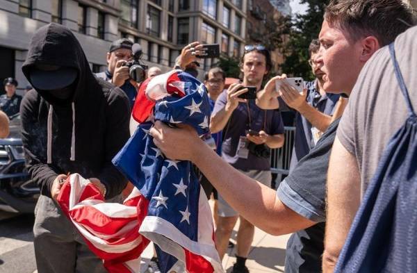 Una persona quema la bandera de Estados Unidos durante una protesta frente a la residencia del alcalde de Nueva York, el demócrata Eric Adams, hoy, en Nueva York (Estados Unidos).