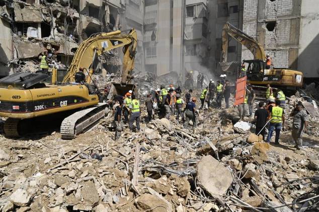 Los trabajadores de emergencia utilizan excavadoras para limpiar los escombros en el lugar que fue blanco de un ataque israelí el día anterior, en el suburbio sur de Beirut, Líbano, el 21 de septiembre de 2024.