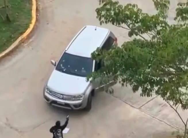 Se ve a un hombre disparando a un auto.