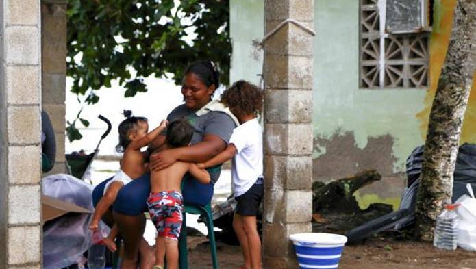 Fotografía del 23 de junio de 2025 de la venezolana Marielbis Eloina Campos, de 33 años, jugando con sus hijos, en el pueblo pesquero de Miramar en el Caribe panameño (Panamá).