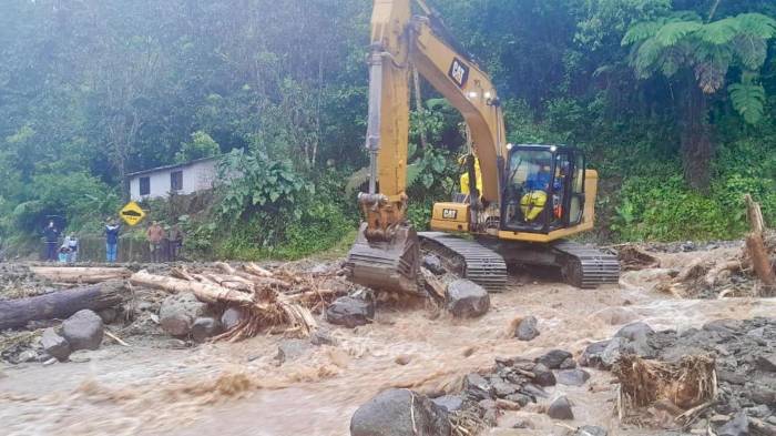 Fotografía cedida por el Ministerio de Obras Públicas que muestra trabajadores mientras operan maquinaria con la que intentan limpiar zonas afectadas por las lluvias en la ciudad de Baños (Ecuador). EFE/Ministerio de Obras Públicas