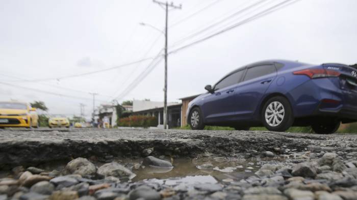 Fotografía del 11 de junio de 2025 de un vehículo pasando por una vía con huecos, en Ciudad de Panamá.