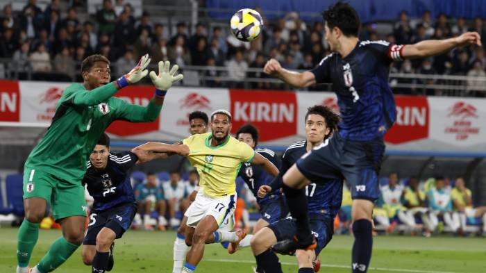 El brasileño Joelinton (C) disputa el balón durante el partido amistoso internacional de fútbol entre Japón y Brasil en Tokio, Japón.
