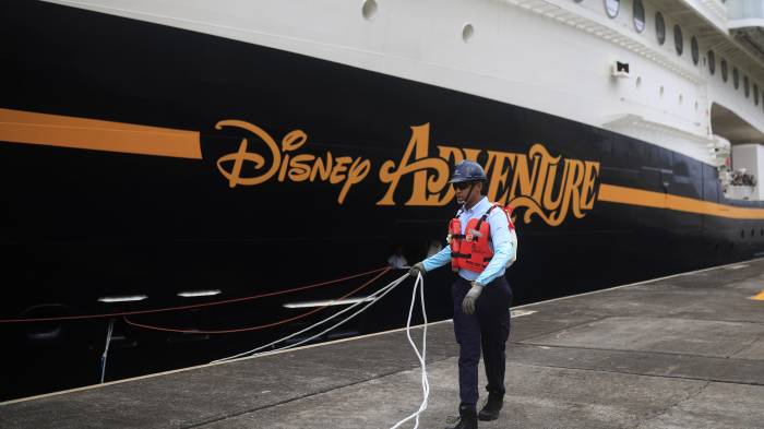 Un trabajador del Canal de Panamá sostiene cuerdas frente al crucero 'Disney Adventure' durante su recorrido en las esclusas Agua Clara este lunes, en Colón (Panamá).