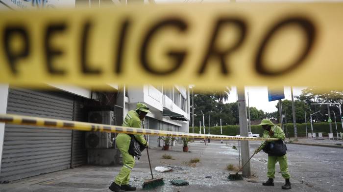 Personal de aseo recoge escombros en una calle cercana a la Escuela Militar de Aviación Marco Fidel Suárez este viernes, en Cali (Colombia).