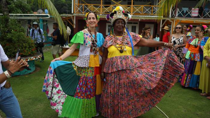 La ministra de Cultura de Panamá, María Eugenia Herrera (i), acompaña a la reina congo de Colón Irma Pinilla Palma en la celebración de los Congos en Portobelo.