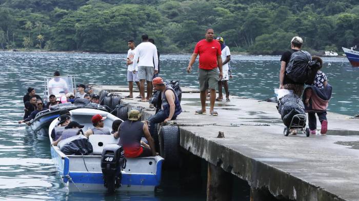 Migrantes abordan embarcaciones el 30 de agosto de 2025 en el puerto de Sapzurro (Colombia).