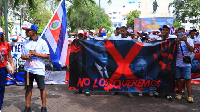 Manifestantes exhiben carteles con imágenes de Miguel Díaz-Canel y Raúl Castro con el mensaje “no los queremos”, durante la protesta por los panameños detenidos en Cuba.