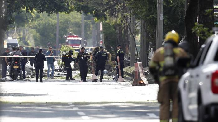 Integrantes de la Policía Nacional inspeccionan la zona del atentado tras una explosión en inmediaciones de la Escuela Militar de Aviación Marco Fidel Suárez este jueves, en Cali (Colombia).