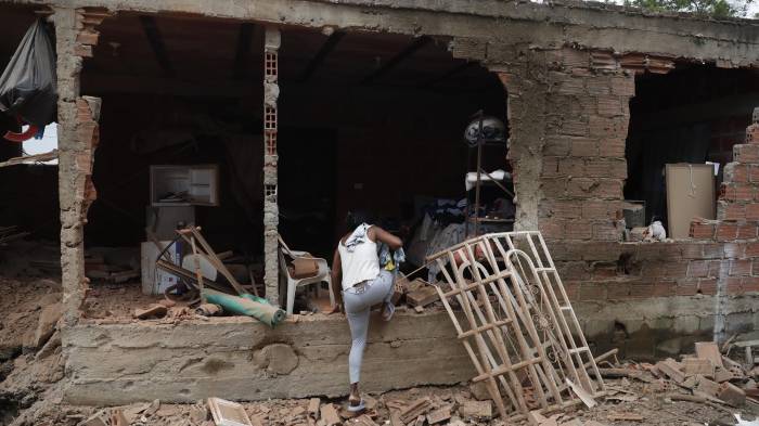 Una mujer entra a su casa afectada por una explosión este jueves, en Robles, Jamundí (Colombia).