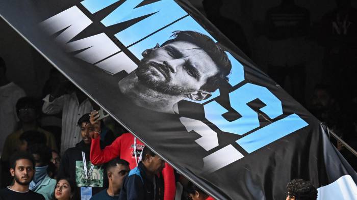 Los espectadores observan cómo un póster roto del futbolista argentino Lionel Messi cuelga del techo durante su Gira GOAT en el Estadio Salt Lake de Calcuta el 13 de diciembre de 2025.