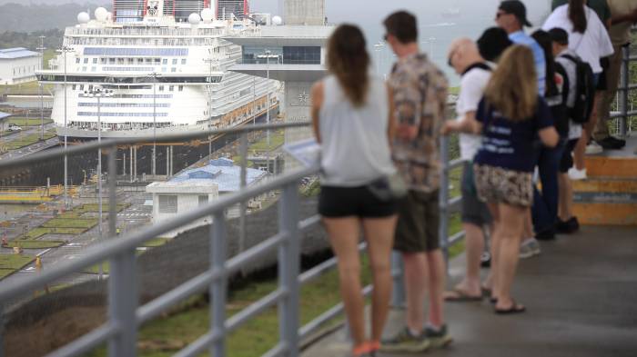 Personas observan el crucero 'Disney Adventure' durante su recorrido en el centro de visitantes de Agua Clara en el Canal de Panamá este lunes, en Colón (Panamá).