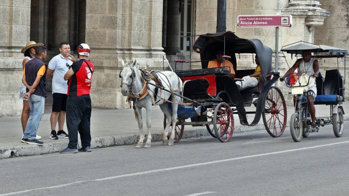 Turistas esperan en una calle este martes, en La Habana. Las calles de La Habana casi sin turistas, incluso en esta Semana Santa.
