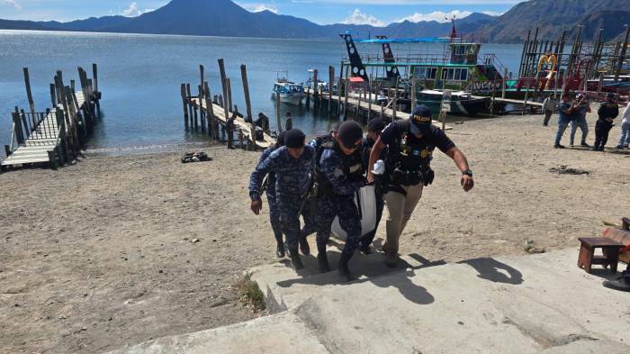 Autoridades y rescatistas trasladan uno de los cuerpos de las víctimas tras el naufragio de una embarcación en el Lago Atitlán.