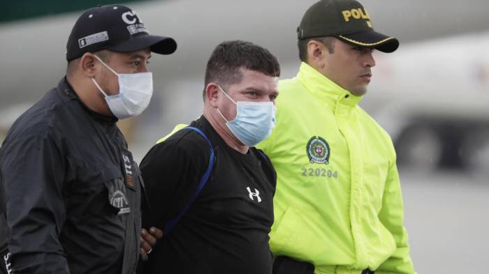 Fotografía de archivo del 8 de junio de 2022 de Francisco Luis Correa Galeano (c) siendo trasladado por un agente de la Policía y del Cuerpo Técnico de Investigación (CTI) en el Comando Aéreo de Transporte Militar (CATAM) hacia el Búnker de la Fiscalía General de la Nación, en Bogotá (Colombia). EFE/ Carlos Ortega