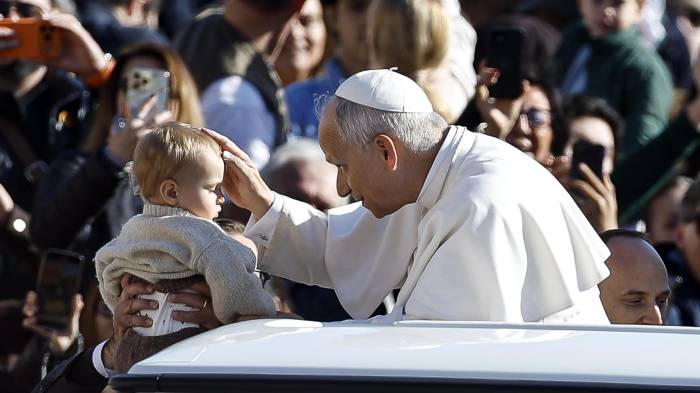 El papa León XIV bendice a un niño desde el papamóvil durante la Audiencia. EFE/EPA/ANGELO CARCONI