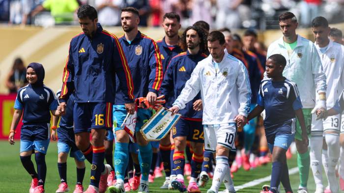 El centrocampista español Rodri, el delantero argentino Lionel Messi y sus compañeros de equipo saltan al terreno de juego antes de la final del Mundial de fútbol de 2026 entre España y Argentina, en el estadio de Nueva York/Nueva Jersey en East Rutherford.