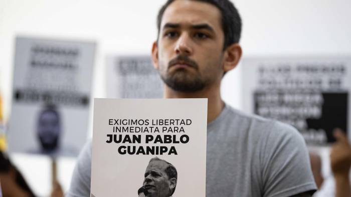 Ramón Guanipa sostiene un cartel de su padre detenido, Pedro Guanipa, en una imagen reciente.