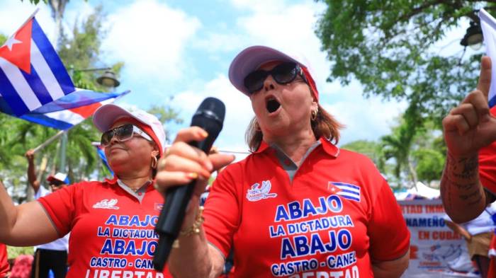 Entre consignas y banderas, mujeres participan en la jornada de protesta por los detenidos en Cuba.