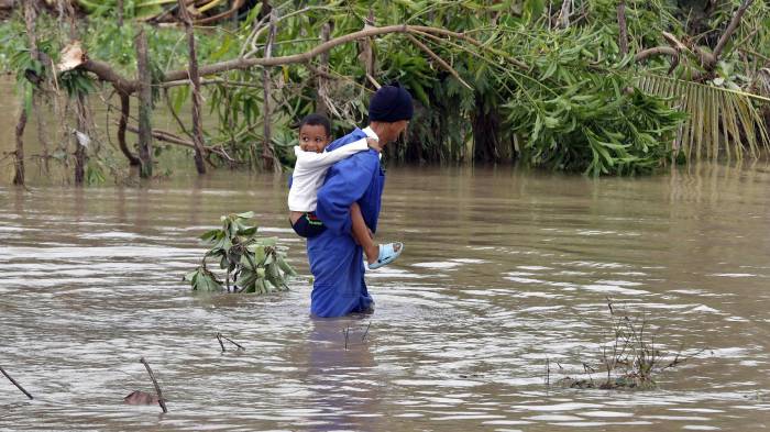 Niño en río crecido en Santiago de Cuba.