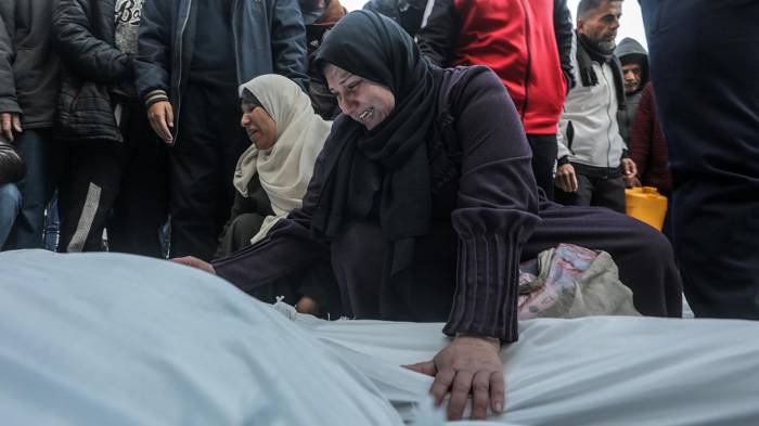 Una mujer palestina llora sobre los cuerpos cubiertos de los miembros de una familia palestina asesinados en un ataque aéreo israelí, en el Hospital de los Mártires de Al Aqsa en la ciudad de Deir Al Balah, en el centro de la Franja de Gaza, 15 de enero de 2025. EFE/EPA/MOHAMMED SABER