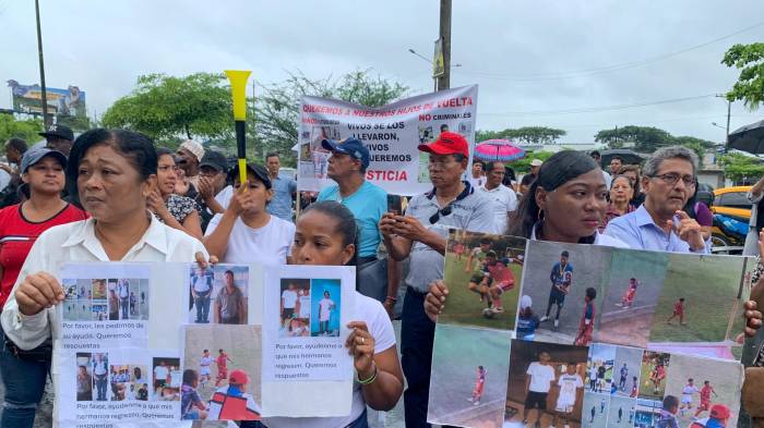 Familiares de los cuatro menores ecuatorianos desaparecidos sostienen carteles durante un plantón en los exteriores de la Fiscalía de Guayaquil este martes, en Guayaquil (Ecuador). EFE/ Cristina Bazán